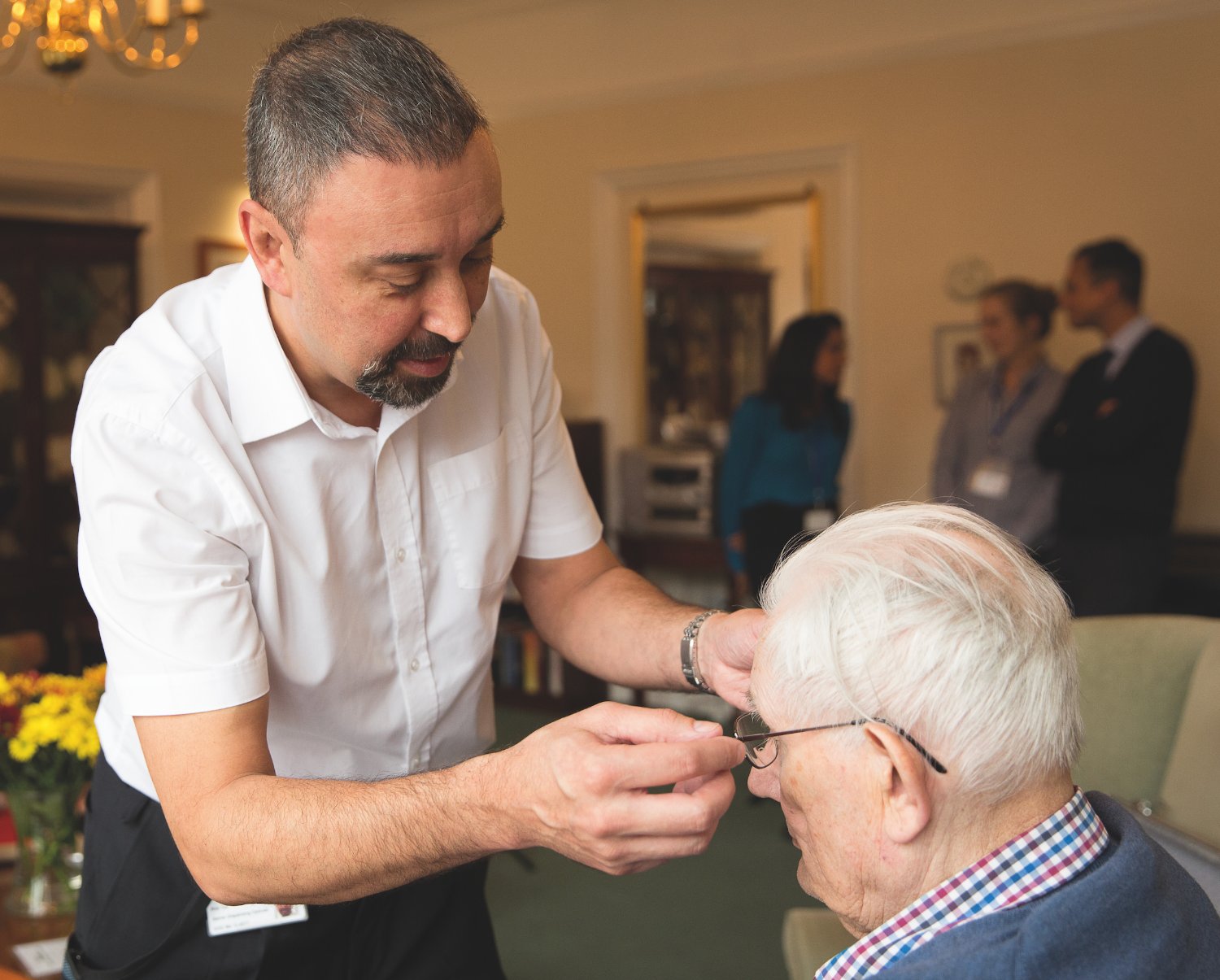 An Opticall optician fitting glasses for an older resident during an on-site care home visit